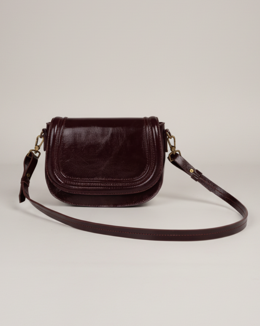 Bolsa crossbody borgoña ángulo 3/4 fondo gris neutro