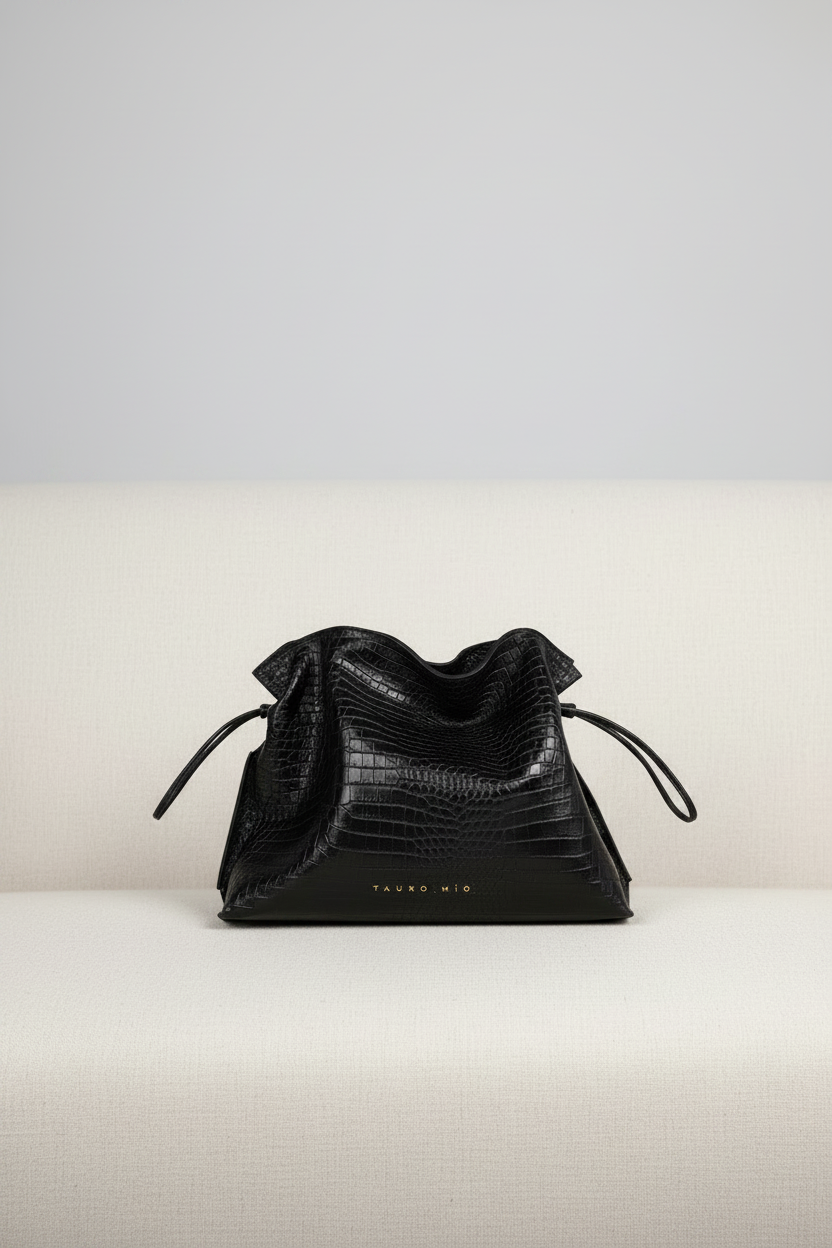 Bolso Antonia Slouchy Coco Negro sobre sofá terciopelo blanco roto — TAUROMÍO